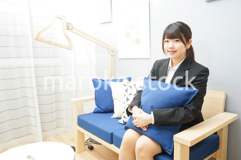 スーツを着てリラックスをする女性