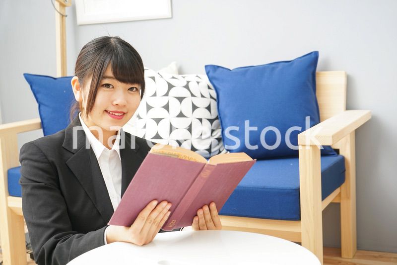 スーツを着て読書をする女性