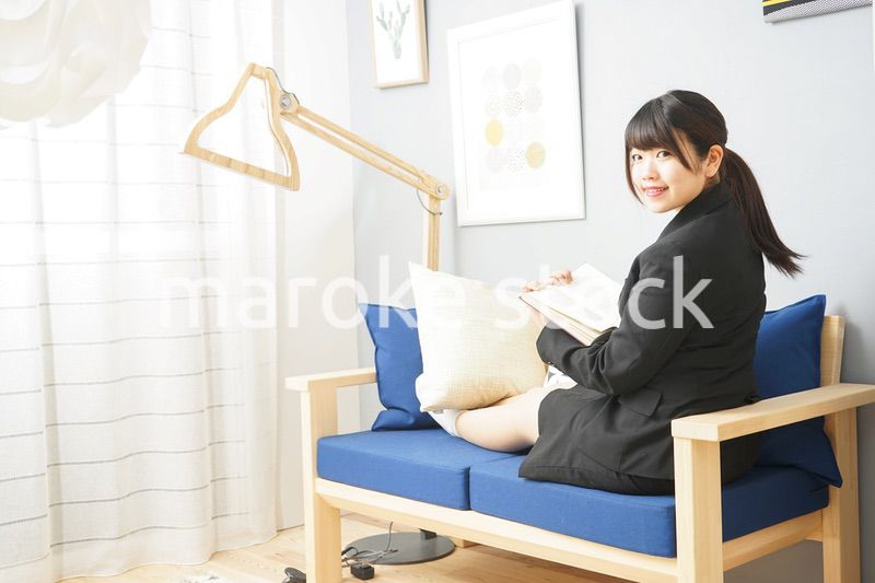 スーツを着て読書をする女性