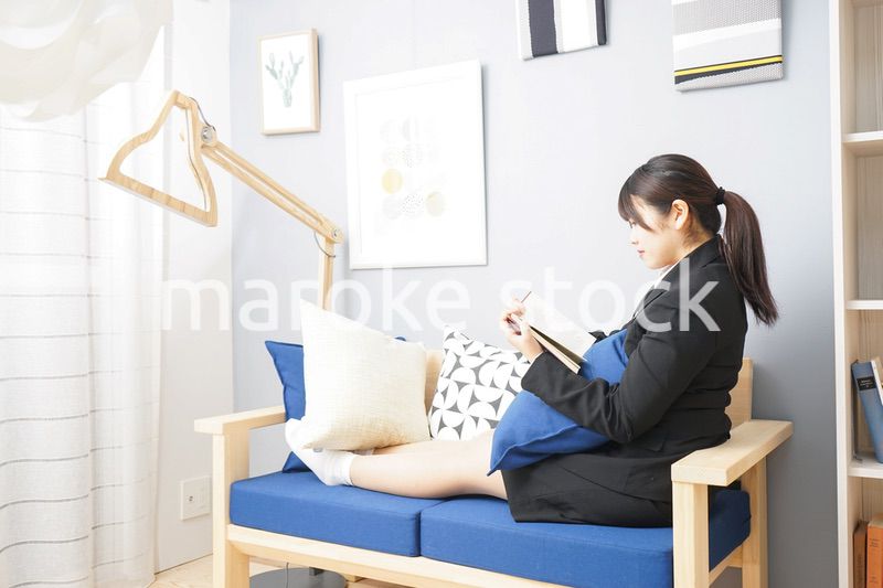 スーツを着て読書をする女性