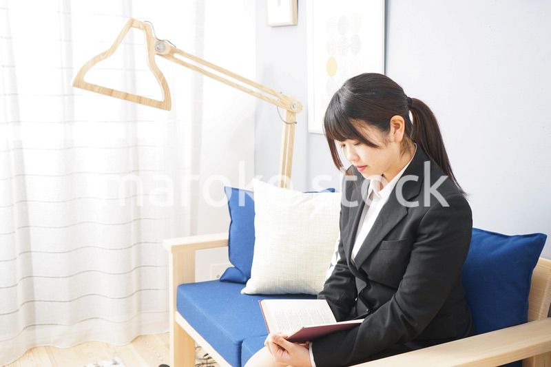 スーツを着て読書をする女性