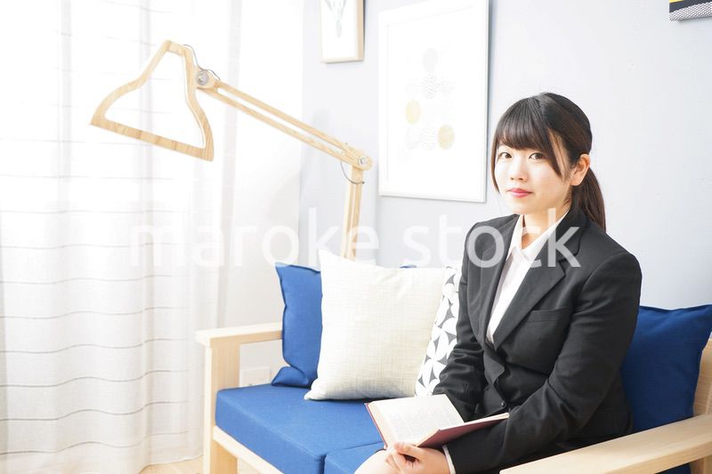 スーツを着て読書をする女性
