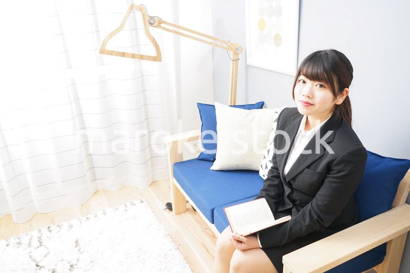 スーツを着て読書をする女性