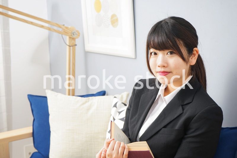 スーツを着て読書をする女性