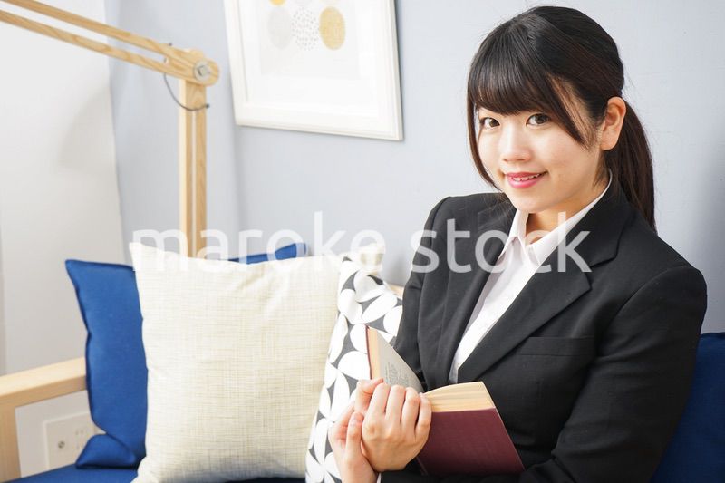 スーツを着て読書をする女性