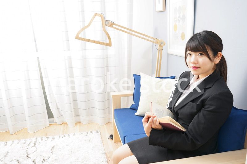 スーツを着て読書をする女性