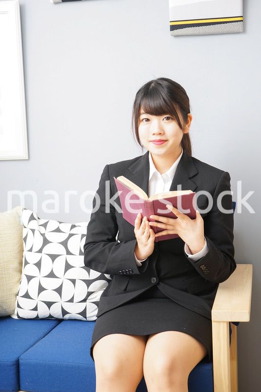 スーツを着て読書をする女性