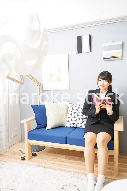 スーツを着て読書をする女性