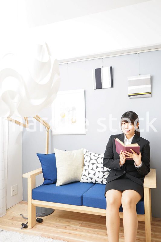 スーツを着て読書をする女性