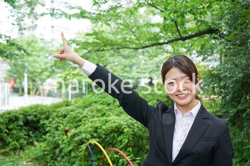 屋外で指をさすビジネスウーマン