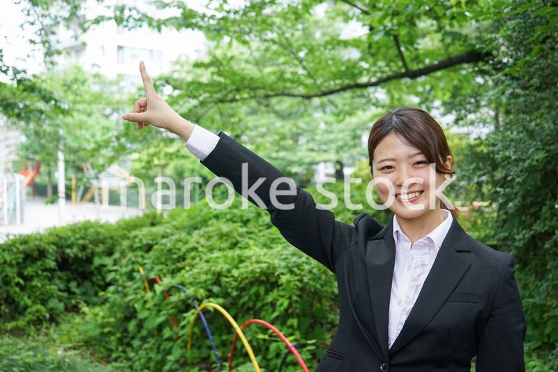 屋外で指をさすビジネスウーマン