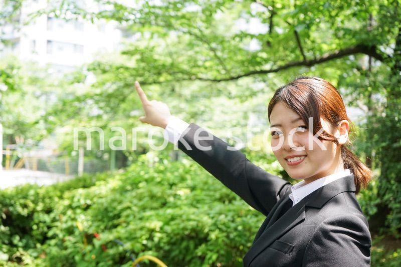 屋外で指をさすビジネスウーマン