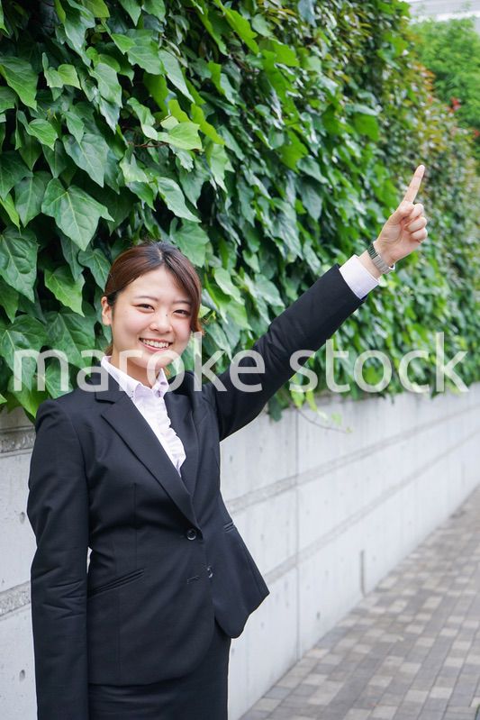 屋外で指をさすビジネスウーマン