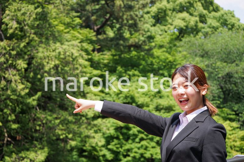 屋外で指をさすビジネスウーマン