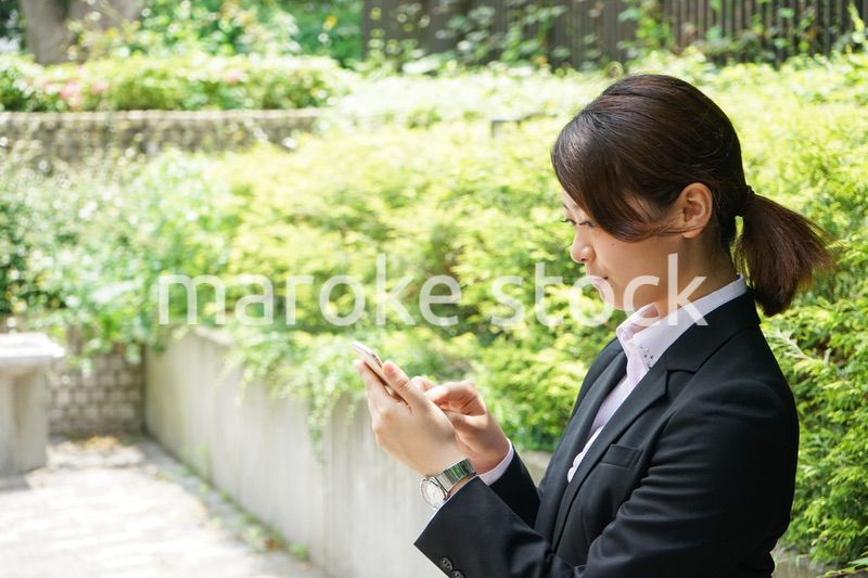 スマホでメッセージを打つビジネスウーマン