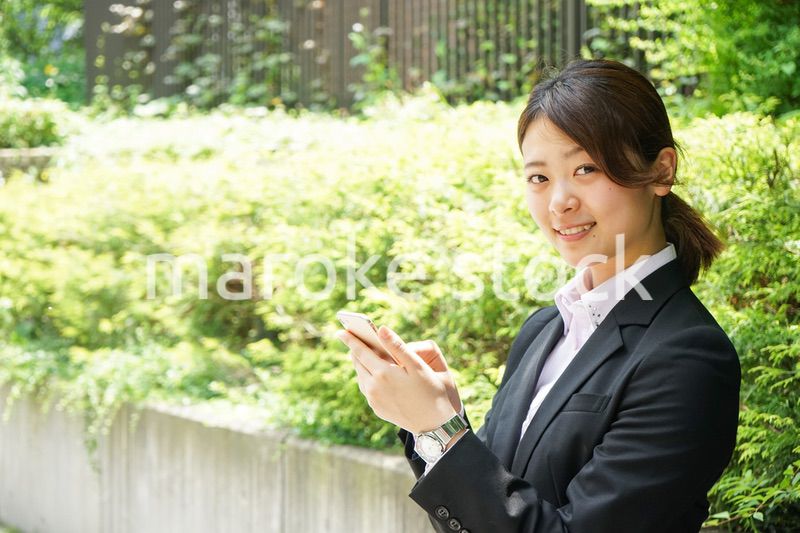 スマホでメッセージを打つビジネスウーマン