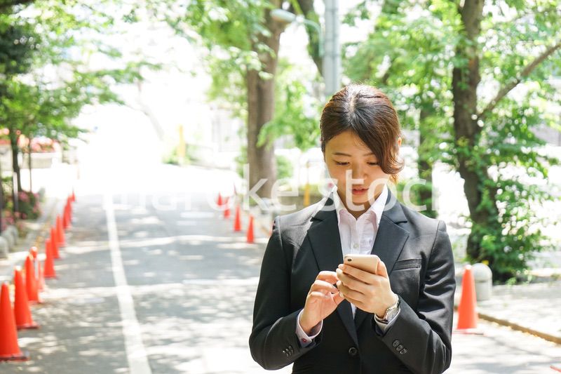 スマホでメッセージを打つビジネスウーマン