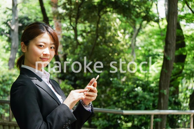 スマホでメッセージを打つビジネスウーマン