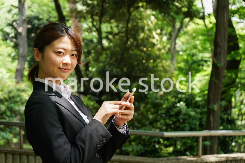 スマホでメッセージを打つビジネスウーマン