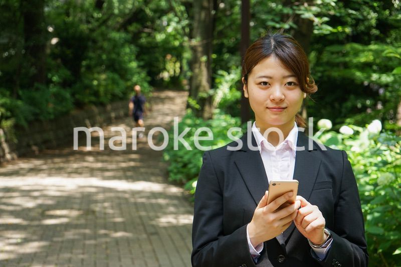 スマホでメッセージを打つビジネスウーマン