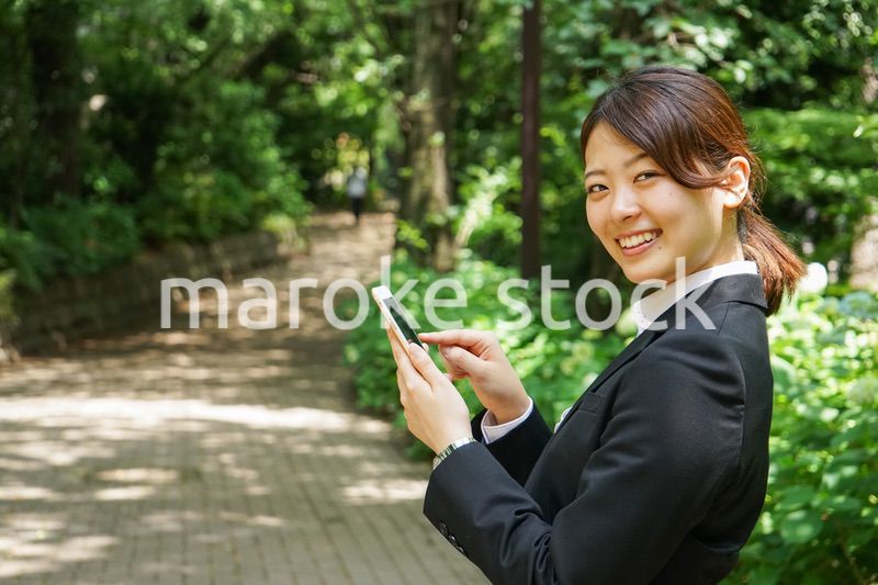 スマホでメッセージを打つビジネスウーマン
