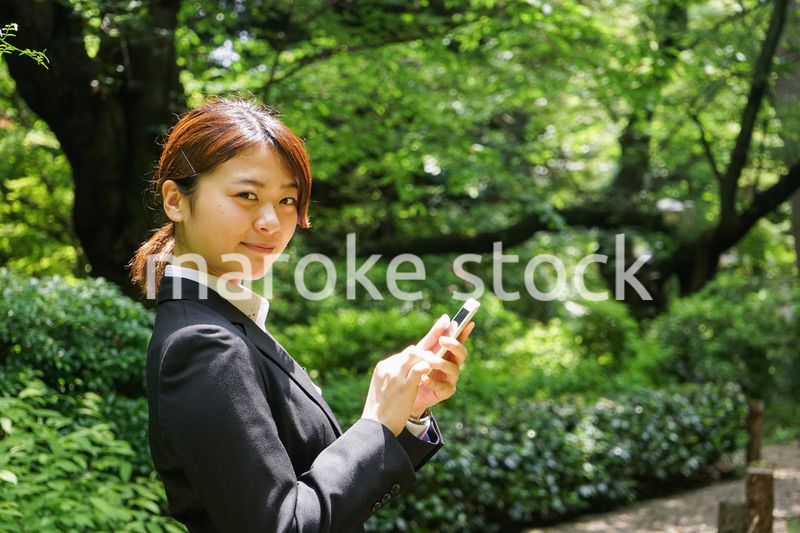 スマホでメッセージを打つビジネスウーマン