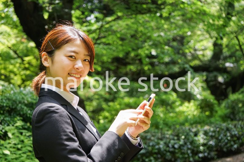 スマホでメッセージを打つビジネスウーマン