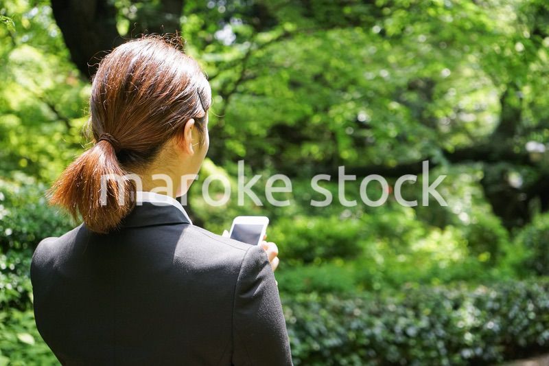 スマホでメッセージを打つビジネスウーマン