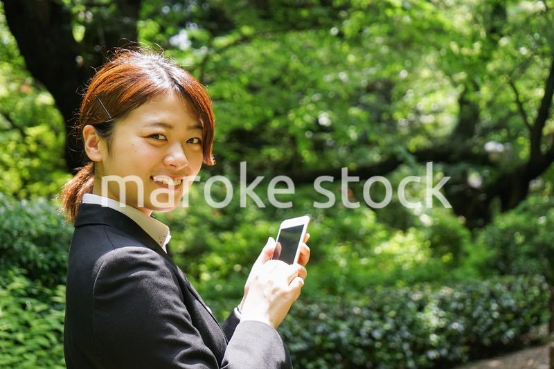 スマホでメッセージを打つビジネスウーマン