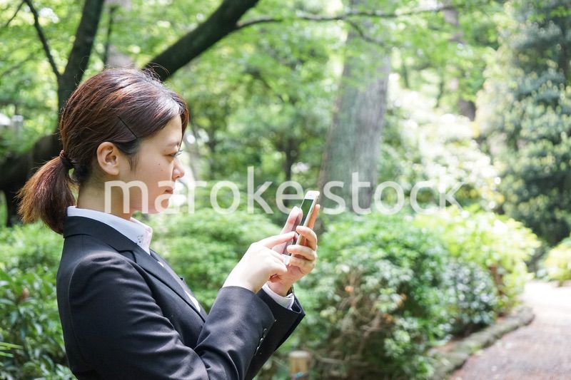 スマホでメッセージを打つビジネスウーマン