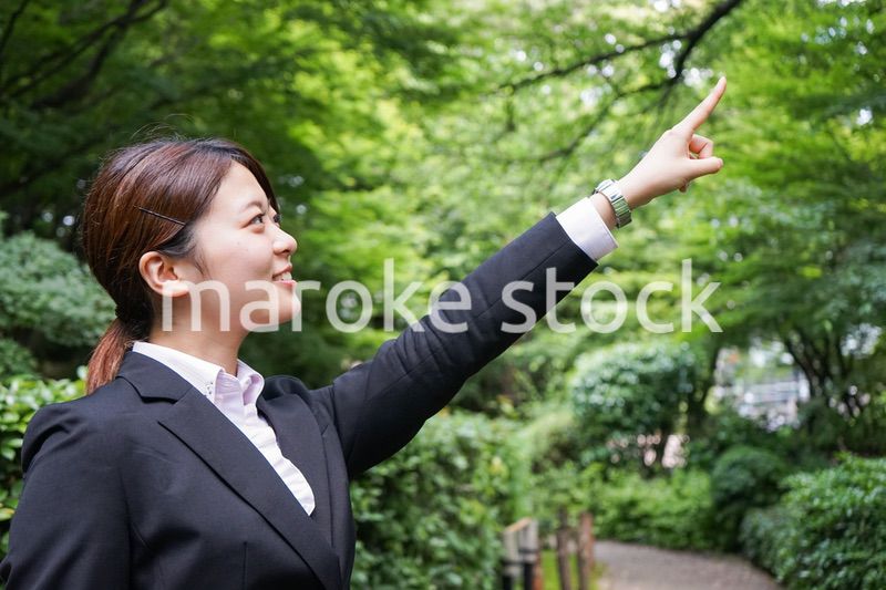 屋外で指をさすビジネスウーマン