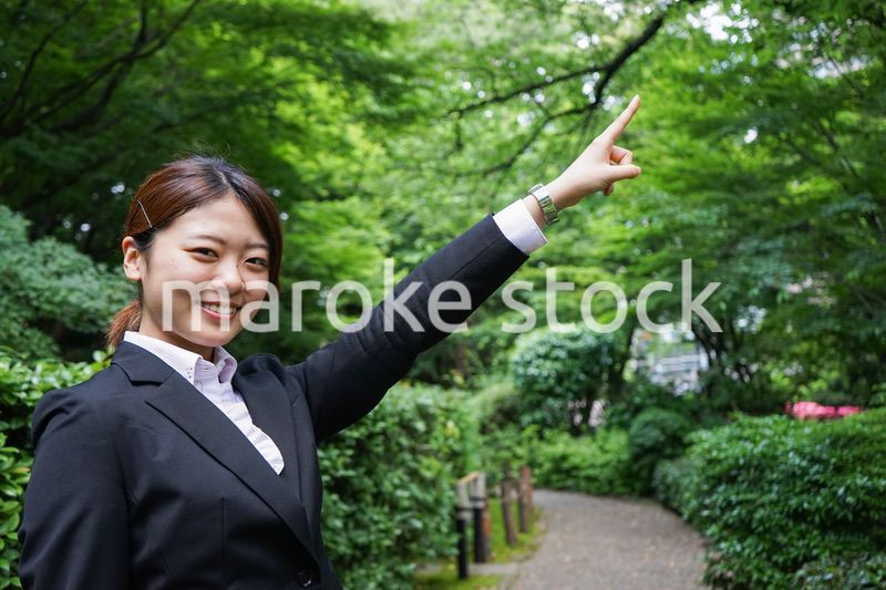 屋外で指をさすビジネスウーマン