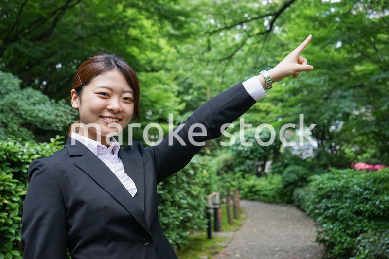 屋外で指をさすビジネスウーマン