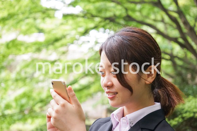 スマホでメッセージを打つビジネスウーマン