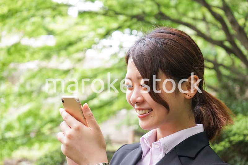 スマホでメッセージを打つビジネスウーマン