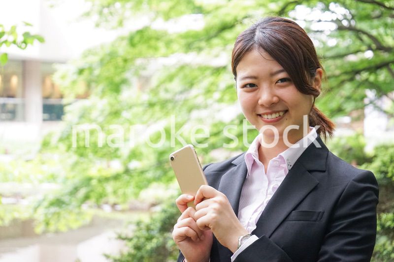 スマホでメッセージを打つビジネスウーマン