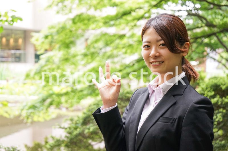 グッドサインをする若いビジネスウーマン