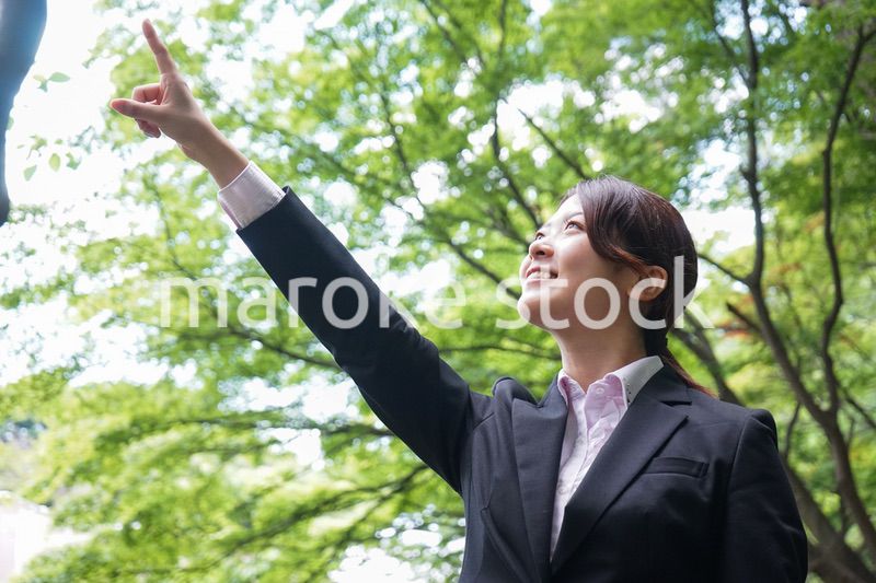 屋外で指をさすビジネスウーマン