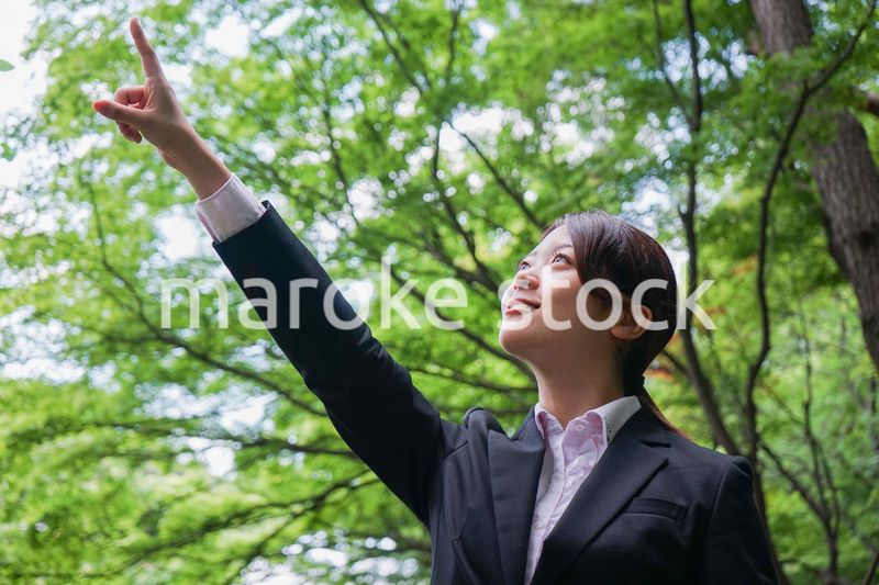 屋外で指をさすビジネスウーマン