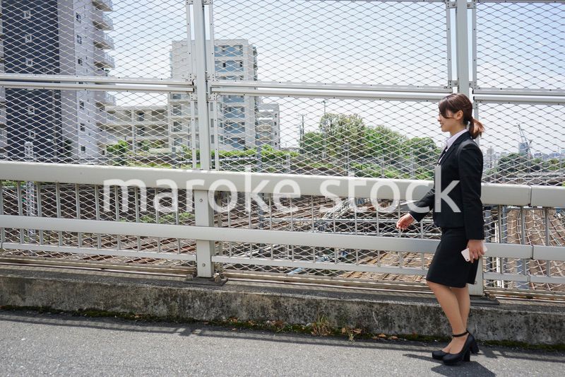 笑顔で外を歩くビジネスウーマン