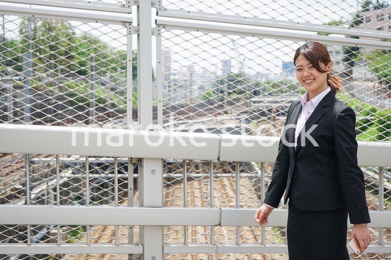 笑顔で外を歩くビジネスウーマン