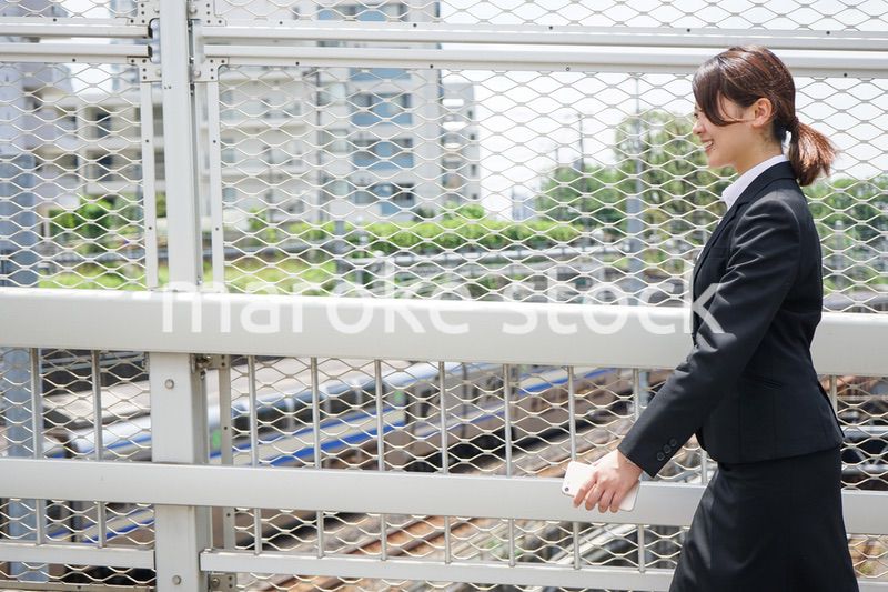 笑顔で外を歩くビジネスウーマン