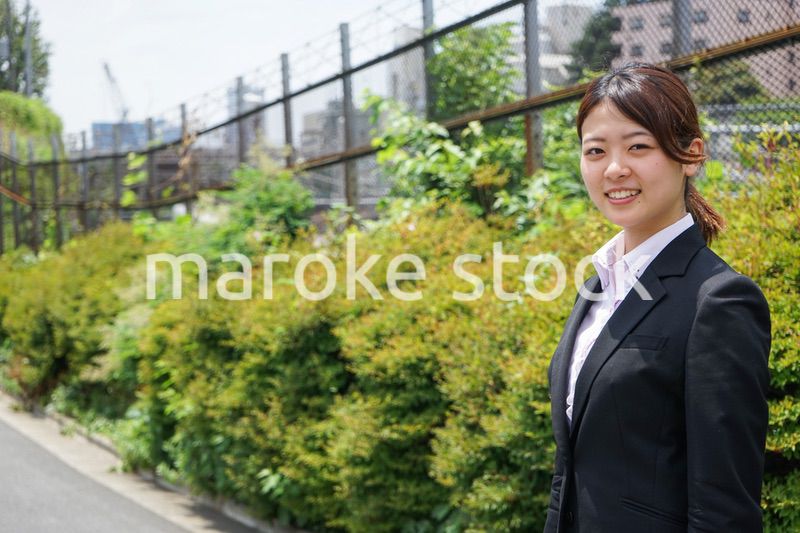 笑顔で外を歩くビジネスウーマン