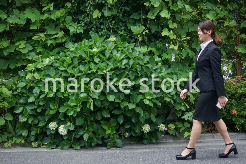 笑顔で外を歩くビジネスウーマン