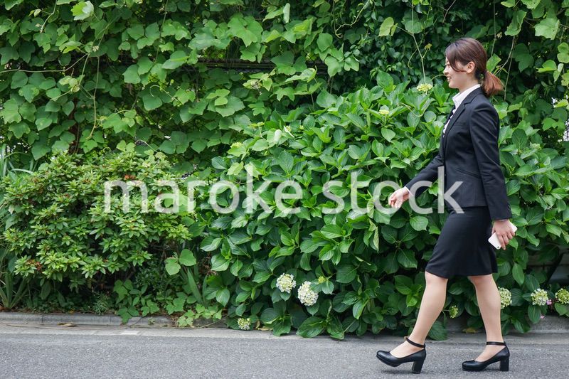 笑顔で外を歩くビジネスウーマン