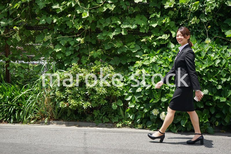 笑顔で外を歩くビジネスウーマン