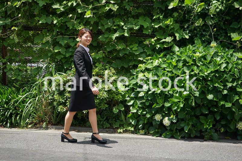 笑顔で外を歩くビジネスウーマン