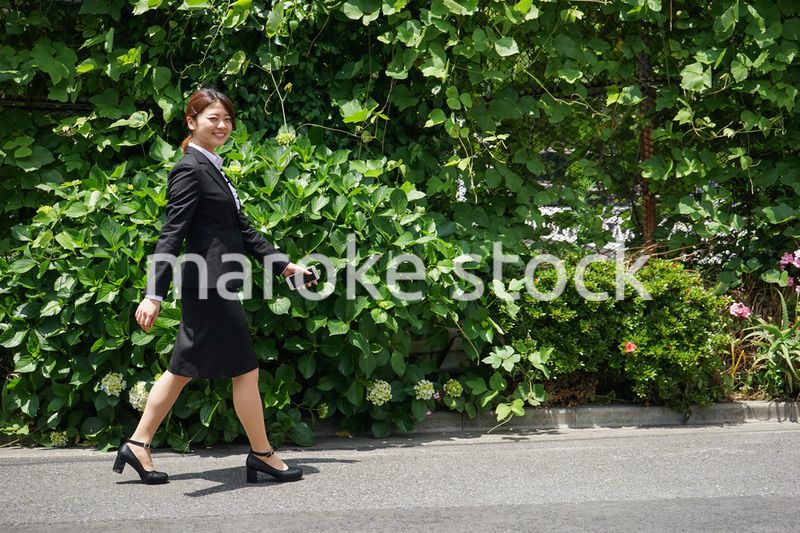 笑顔で外を歩くビジネスウーマン