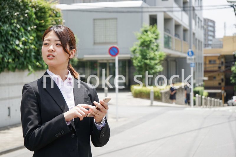 スマホで場所を探す若いビジネスウーマン