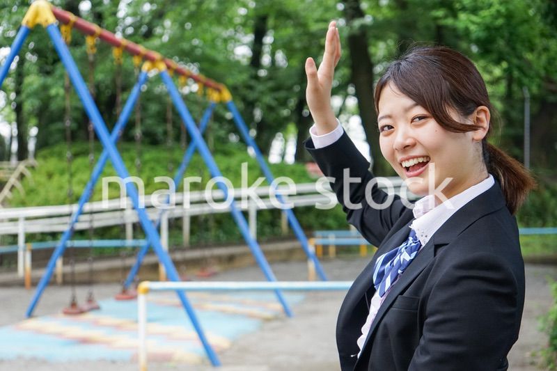 笑顔で手を振る制服姿の学生